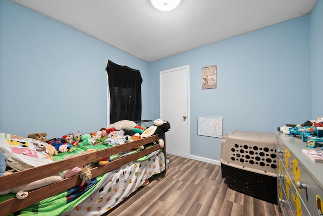 bedroom with hardwood / wood-style floors and a textured ceiling