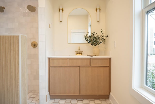 bathroom with vanity and a tile shower