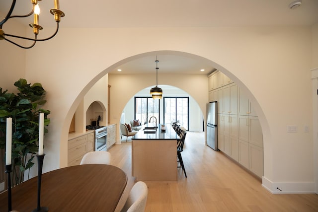 dining space with an inviting chandelier and light hardwood / wood-style flooring