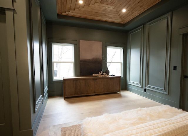 office space featuring wood ceiling, a raised ceiling, and light hardwood / wood-style floors