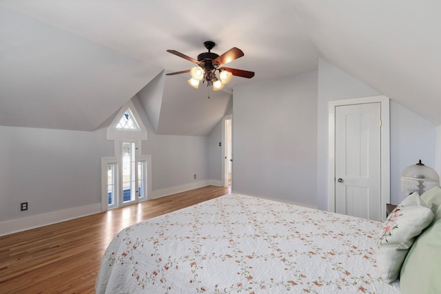 unfurnished bedroom featuring hardwood / wood-style flooring, ceiling fan, and vaulted ceiling