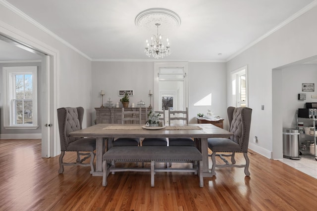 dining room with crown molding, hardwood / wood-style floors, and a chandelier