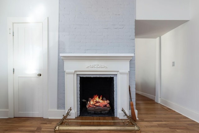 room details featuring a brick fireplace and hardwood / wood-style floors