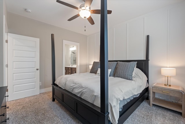 bedroom with ceiling fan, light colored carpet, and ensuite bath