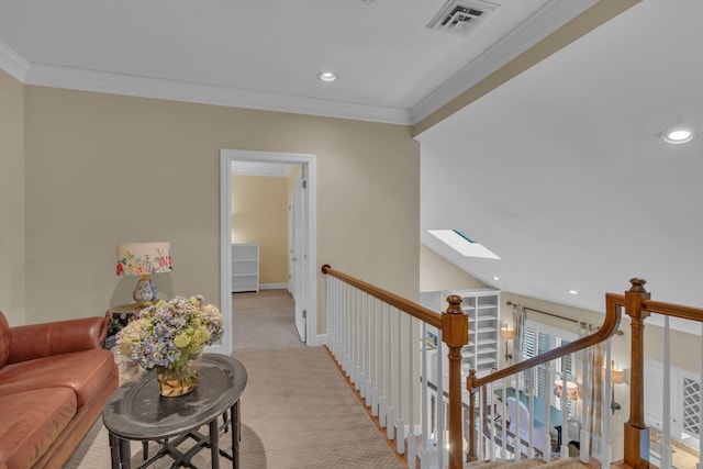 corridor with crown molding, light colored carpet, and a skylight