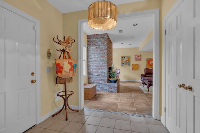 foyer with light tile patterned floors, a chandelier, and baseboards