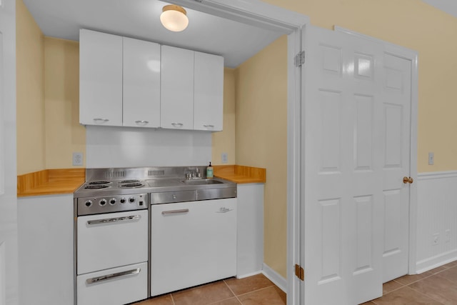 kitchen with white cabinetry, sink, white electric range oven, and light tile patterned floors