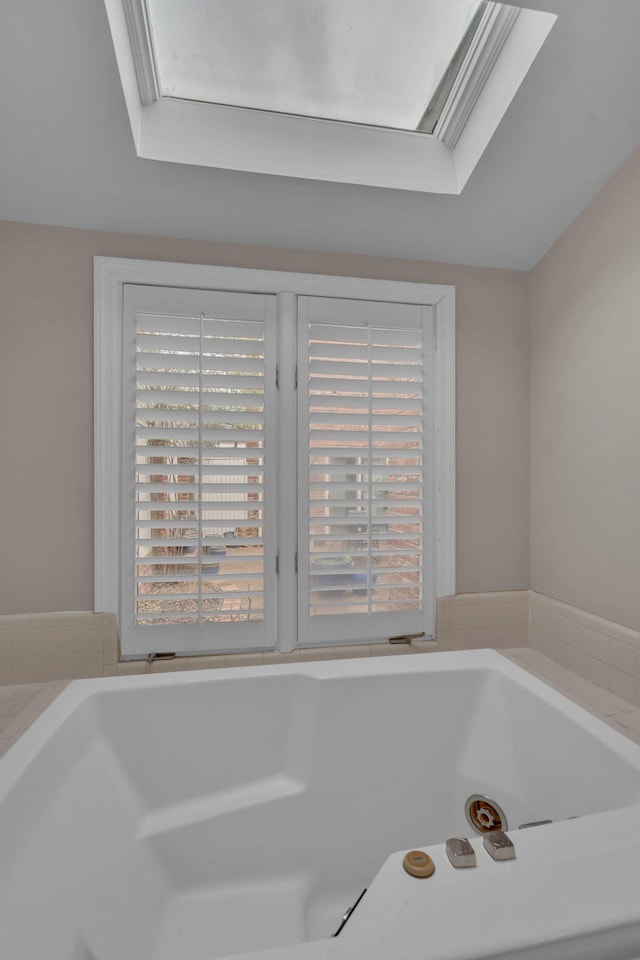 bathroom with a skylight and a washtub