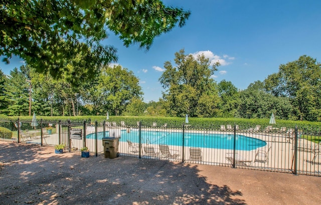 community pool with a patio area and fence