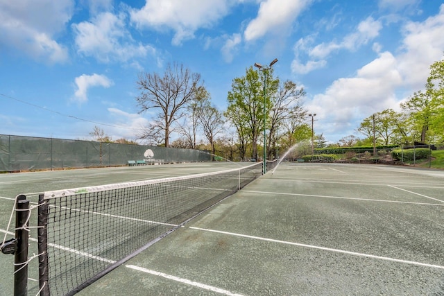 view of tennis court featuring fence