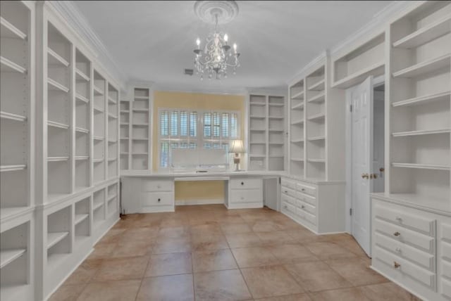 walk in closet featuring light tile patterned flooring, a notable chandelier, and built in desk