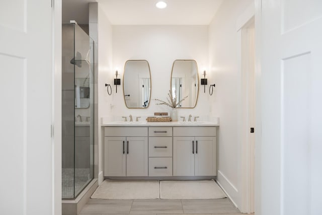 bathroom with vanity and a shower with door