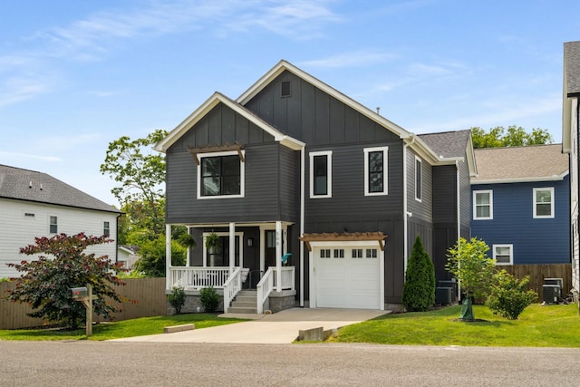 view of front of house with central AC, a garage, covered porch, and a front lawn