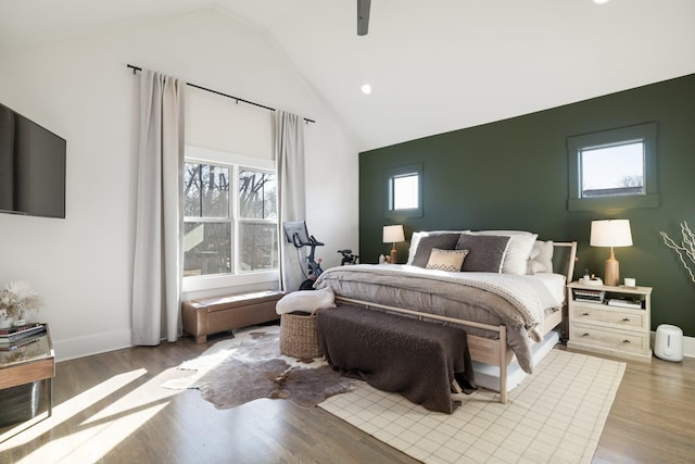 bedroom with multiple windows, light hardwood / wood-style floors, ceiling fan, and lofted ceiling