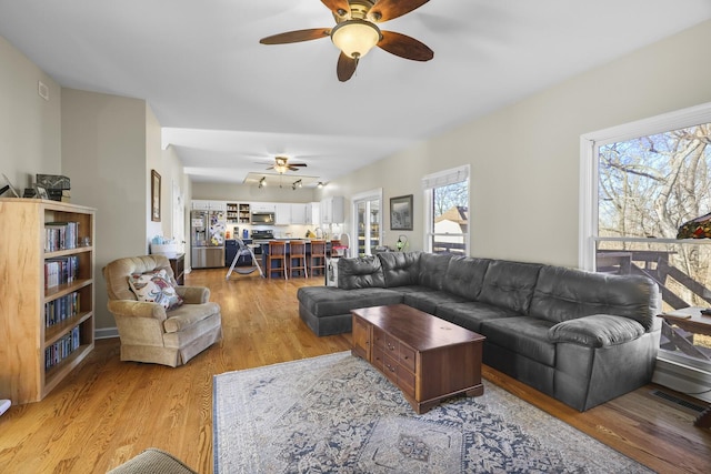 living room featuring ceiling fan and light wood-type flooring