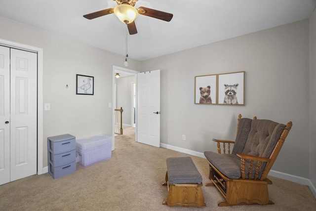 living area with light colored carpet and ceiling fan