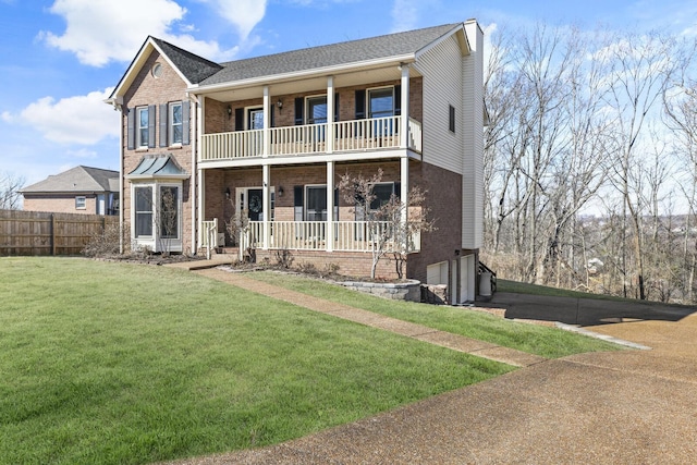 view of front of property featuring a balcony, a front yard, and covered porch