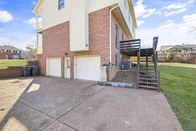 view of side of home with a garage, a yard, and central air condition unit