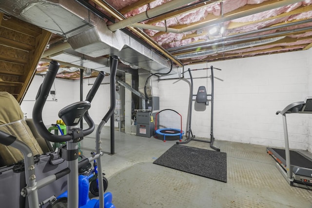 exercise room featuring heating unit and water heater