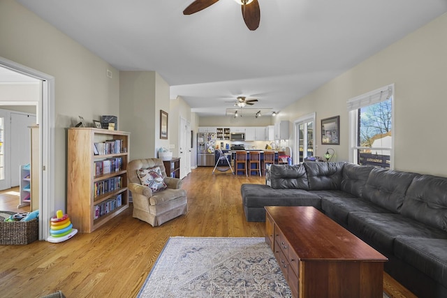 living room with ceiling fan and light hardwood / wood-style floors