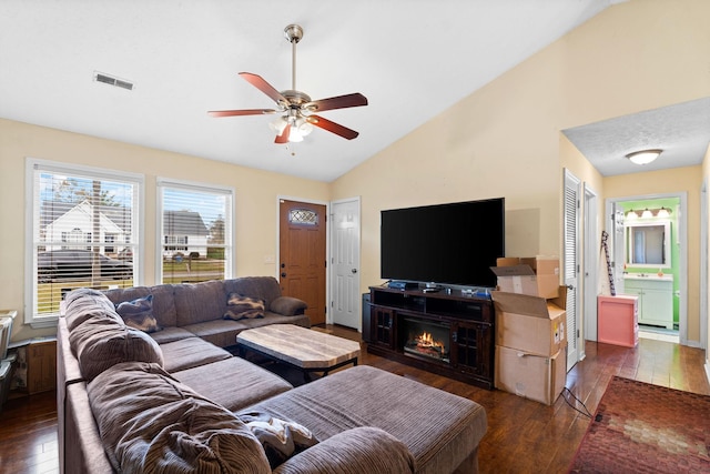 living room featuring ceiling fan, dark hardwood / wood-style flooring, and vaulted ceiling