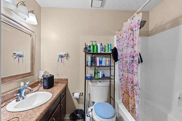 full bathroom with shower / bath combination with curtain, vanity, toilet, and a textured ceiling