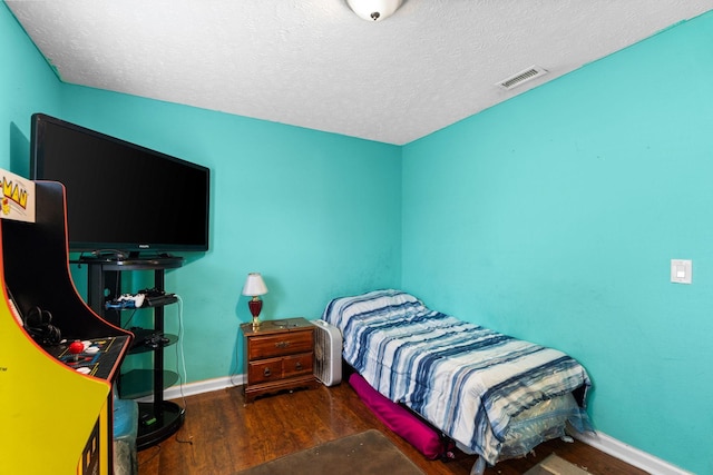 bedroom with dark wood-type flooring and a textured ceiling