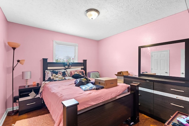 bedroom with dark hardwood / wood-style flooring and a textured ceiling