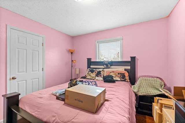 bedroom with hardwood / wood-style flooring and a textured ceiling