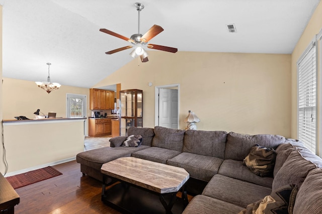 living room with lofted ceiling, dark hardwood / wood-style flooring, and ceiling fan with notable chandelier