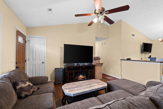 living room featuring ceiling fan, dark hardwood / wood-style floors, and vaulted ceiling