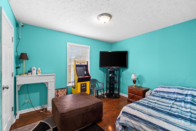 bedroom with dark hardwood / wood-style flooring and a textured ceiling