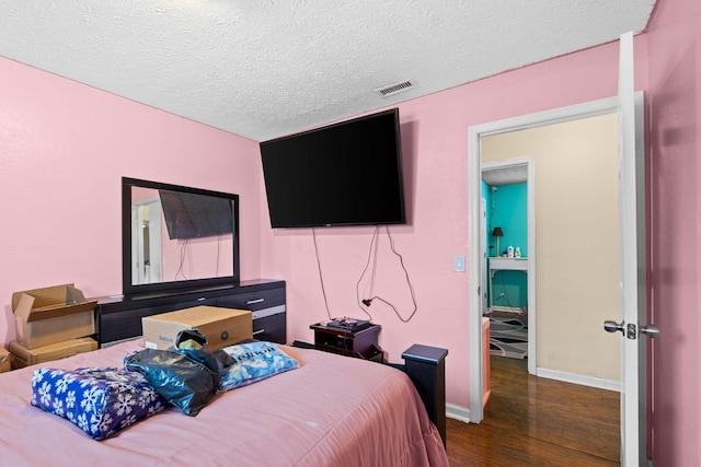 bedroom with dark wood-type flooring and a textured ceiling