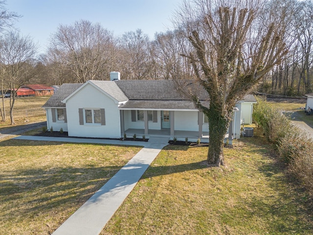 view of front facade with a porch, a shed, a front yard, and central air condition unit