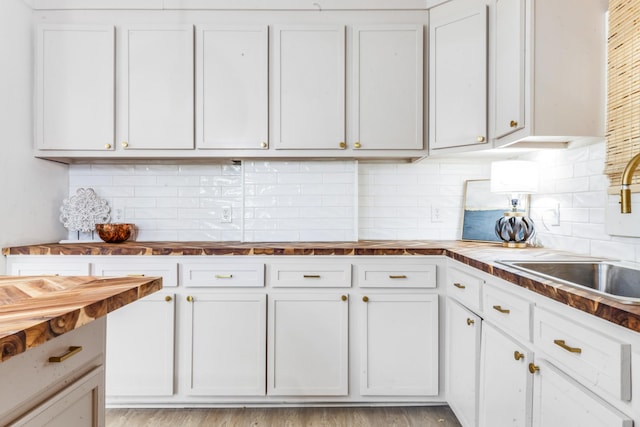 kitchen featuring tasteful backsplash, sink, and white cabinets