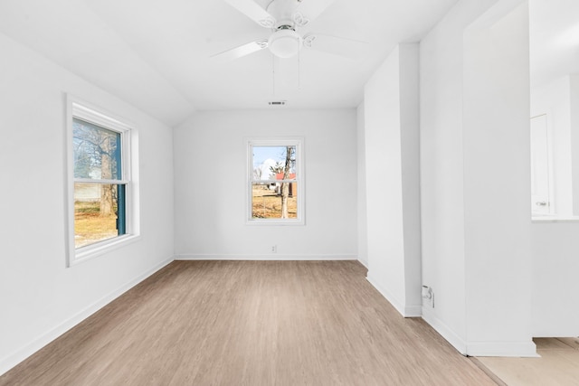 unfurnished room featuring lofted ceiling, a wealth of natural light, ceiling fan, and light hardwood / wood-style flooring