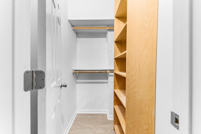 walk in closet with hardwood / wood-style floors