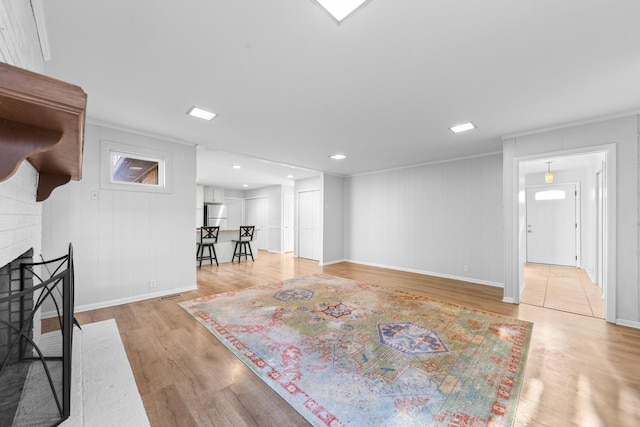 living room with a brick fireplace and light wood-type flooring