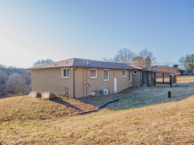 rear view of property with a sunroom and a yard