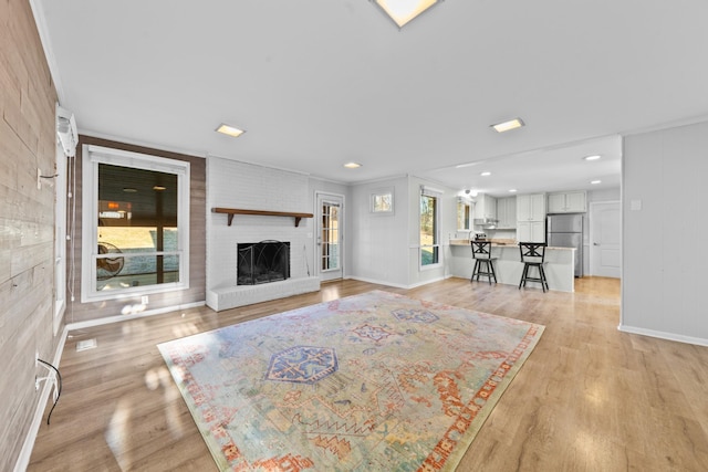 unfurnished living room with a fireplace and light hardwood / wood-style floors