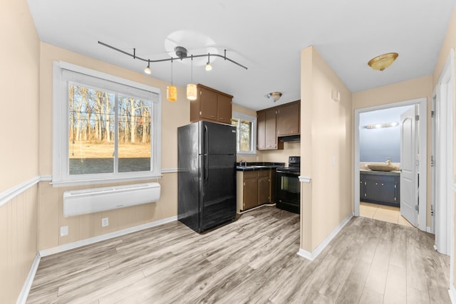 kitchen with dark brown cabinetry, sink, light hardwood / wood-style flooring, and black appliances