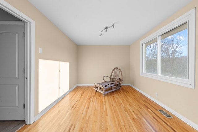 unfurnished dining area with rail lighting and hardwood / wood-style floors