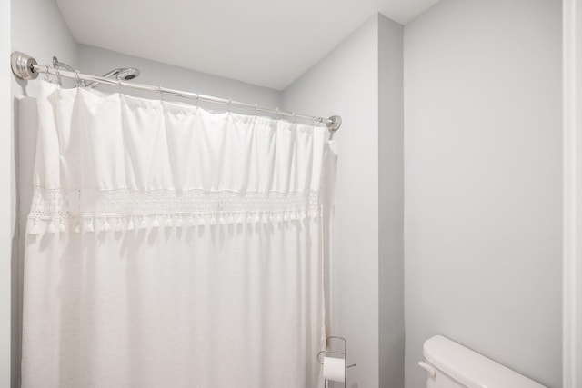 bathroom with curtained shower and toilet