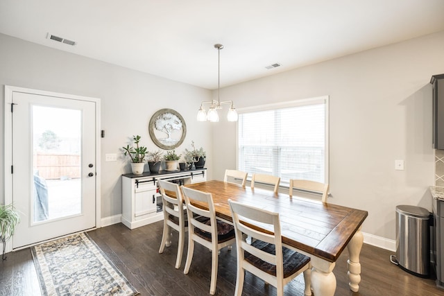 dining space with an inviting chandelier and dark hardwood / wood-style flooring