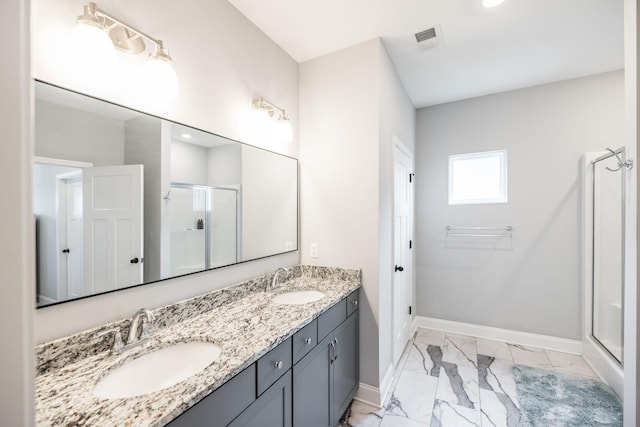 bathroom featuring a shower with door and vanity