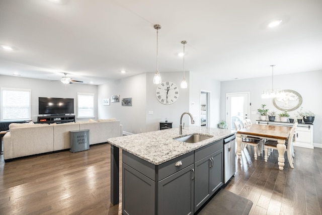 kitchen with sink, dark hardwood / wood-style flooring, gray cabinets, pendant lighting, and light stone countertops