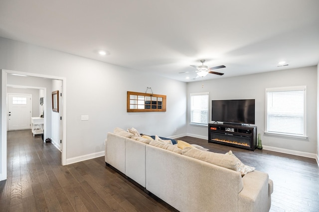 living room with dark wood-type flooring and ceiling fan