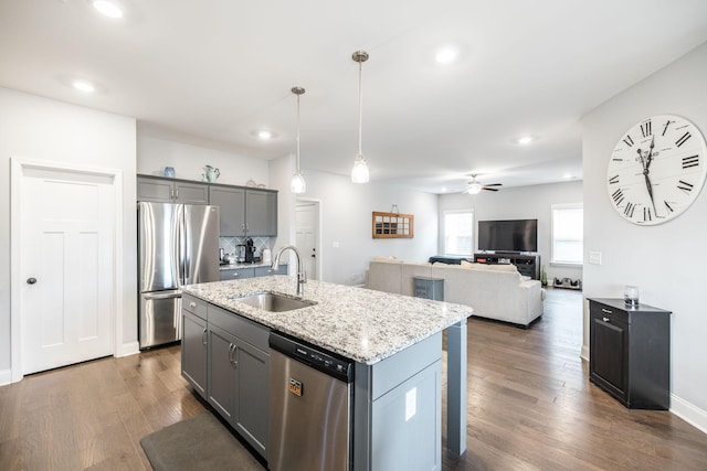 kitchen featuring an island with sink, appliances with stainless steel finishes, sink, and gray cabinetry