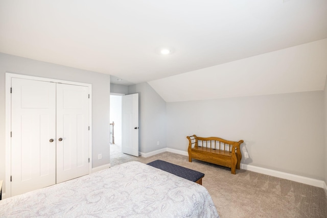 carpeted bedroom with lofted ceiling and a closet