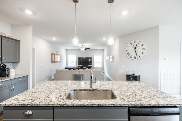 kitchen with sink, gray cabinets, an island with sink, and dishwasher